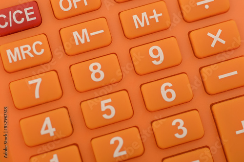 a close-up of an orange calculator, highlighting the numerical keys and basic arithmetic functions commonly used in everyday calculations.