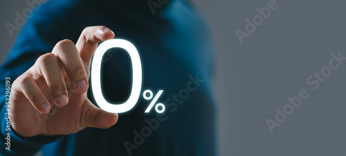 A person in a dark shirt touches a glowing 0% sign, representing zero percent, offers, discounts, promotions, or interest rates on a gray background.