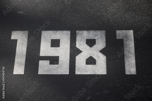 A black granite slab with white numbers 1981 on it