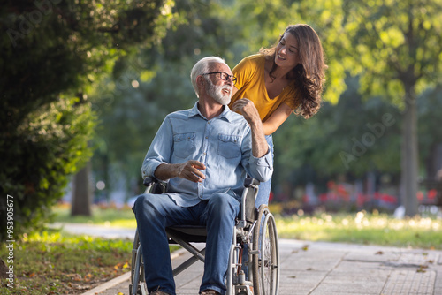 Woman pushing man in wheelchair in park