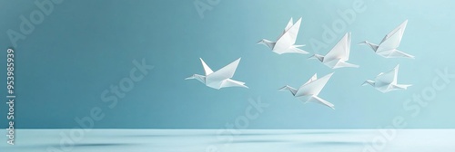 Six white origami birds gracefully soar in a zigzag formation against a light blue background, symbolizing freedom, hope, unity, peace, and the pursuit of dreams.