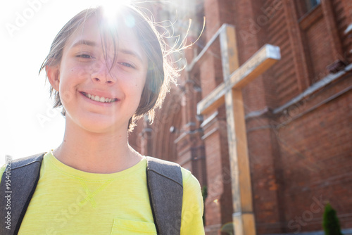 portrait of an 11 year old happy boy in front of a Catholic church