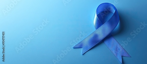 Blue awareness ribbon with a trail on a blue background symbolizing awareness for Acute Respiratory Distress Syndrome ARDS Juvenile Arthritis and Tuberous Sclerosis. with copy space image