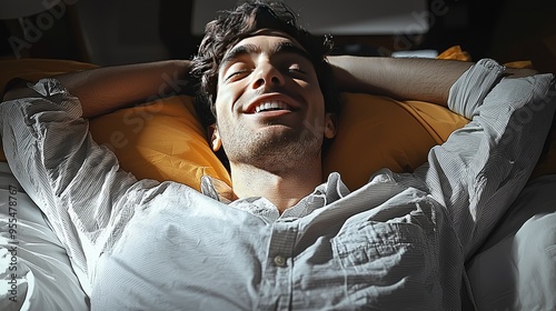 Man Lying in Bed Smiling with Arms Behind Head