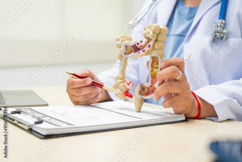 A female doctor sits at a table in a hospital, discussing intestinal health issues, including appendicitis, colon cancer symptoms, diarrhea,constipation, blood in stool, unexplained weight loss