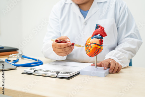 A female doctor works at a desk in the hospital,discussing heart diseases such as coronary artery disease,arrhythmia,heart valve stenosis,heart failure congenital heart disease, emphasizing symptoms