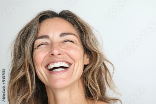 Close up portrait of a beautiful middle aged woman laughing against white background