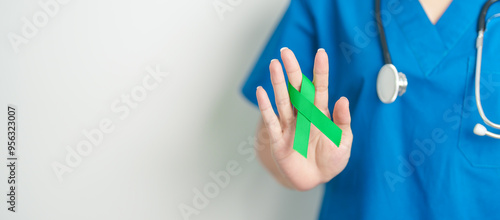 Doctor with green Ribbon for world Lymphoma Awareness September month, world Mental Health Day, Liver, Gallbladders, bile duct, cervical, kidney Cancer. Healthcare and world cancer day concept