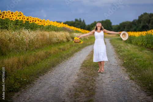 Eine Frau fühlt sich frei in der Natur an einem Sonnenblumenfeld