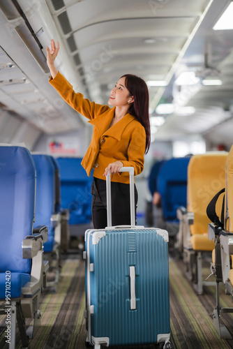 Ready for Takeoff: A young woman stows her luggage in the overhead compartment, her eyes sparkling with anticipation for the journey ahead. 