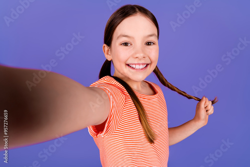 Photo portrait of pretty little girl take selfie photo touch pull hair wear trendy red outfit isolated on purple color background