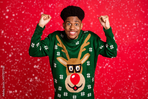 Portrait of attractive lucky cheerful guy wearing ugly jumper having fun rejoicing isolated over bright red color background