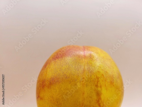 One tasty nectarine on a bright background.