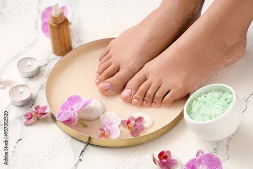 Woman undergoing spa pedicure treatment on white background