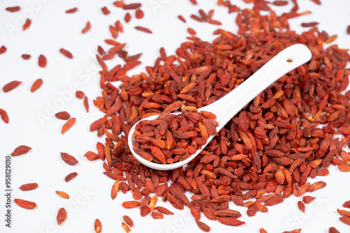 Dried Goji berries Lycium barbarum in a spoon on a white background