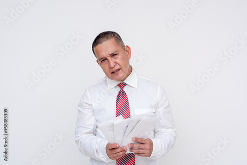 A middle-aged office professional looks miffed while holding envelopes containing past due bills. Isolated on a white background.