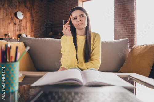 Photo of teen girl sit sofa online lesson webcam netbook skeptical minded dressed yellow outfit cozy day light home interior living room