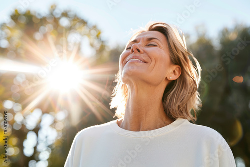 Portrait of happy mature woman enjoying wonderful sunny day in nature