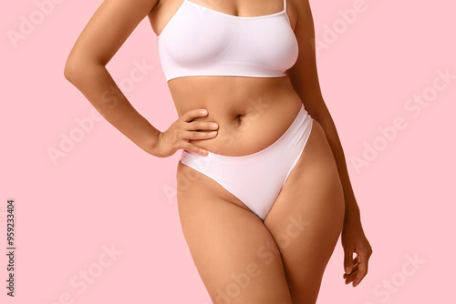 Beautiful young African-American body positive woman on pink background, closeup