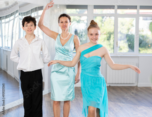 Young couple of teenagers in evening dresses are learning to dance an polonaise dance