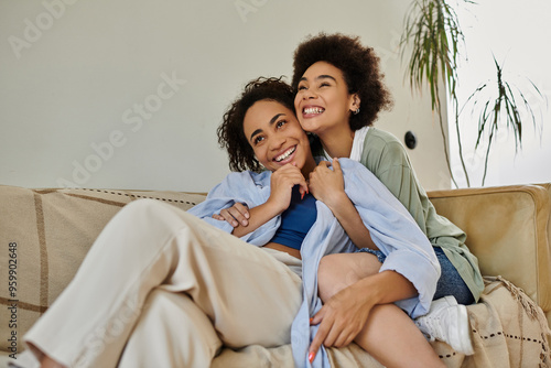 Two women share a joyful embrace, surrounded by comfort and warmth at home.