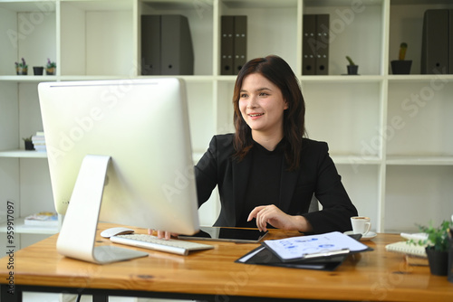 Confident young businesswoman review financial data on computer monitor