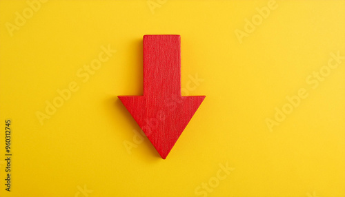 Red wooden arrow pointing down on yellow background. Business, market decline or economic