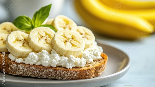 Fresh banana slices on a creamy cottage cheese toast, garnished with basil, perfect for a nutritious snack or breakfast.