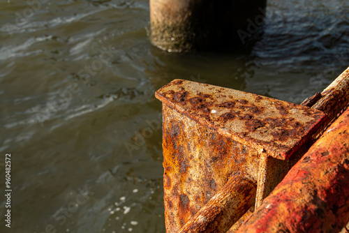 Pilar metálico oxidado en la orilla del East River en Nueva York, EE. UU. Viga metálica en la orilla del río afectada por el espray marino del agua salobre de la bahía en la isla de Manhattan.