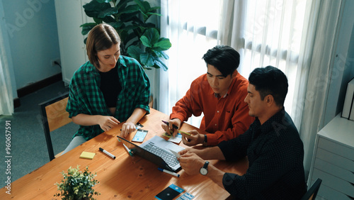 Top down view of project manager present startup project while caucasian investor writing idea and looking at laptop screen display program. Creative business team discussing strategy. Convocation.