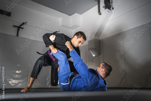 BJJ Brazilian Jiu jitsu Athlete fighters training sparing technique at the academy fight in gi kimono