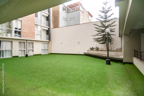 Patio de condominio con cesped sintetico