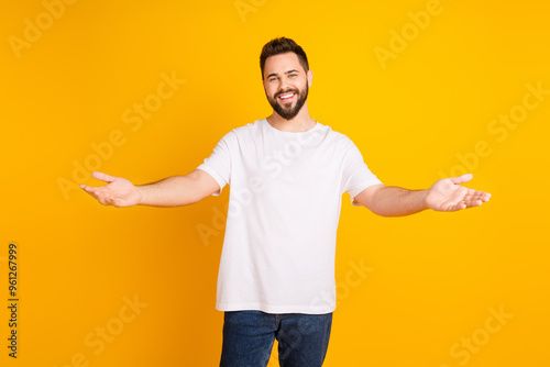 Photo portrait of attractive young man stretch hands want embrace hi dressed stylish white clothes isolated on yellow color background