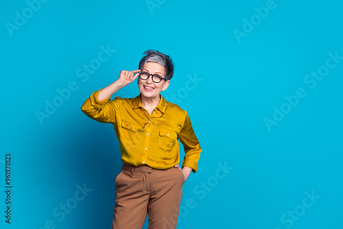 Photo of confident attractive lady dressed shirt glasses smiling emtpy space isolated blue color background