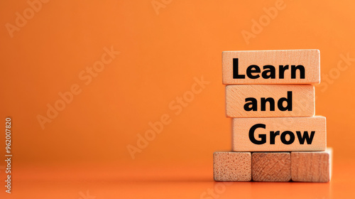 Wooden blocks spelling "Learn and Grow" sit on a bright orange background. This image represents the idea of learning and growing in business. There's space for you to add your own message.