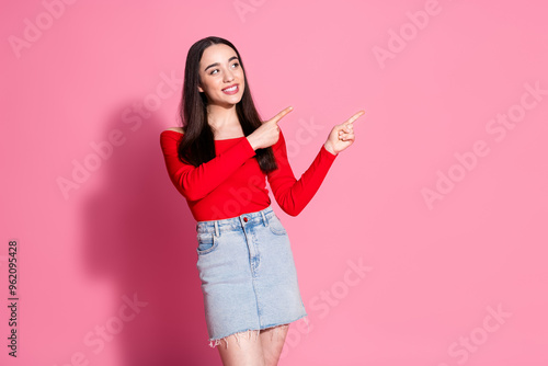 Portrait of pretty young woman look point fingers empty space isolated on pink color background