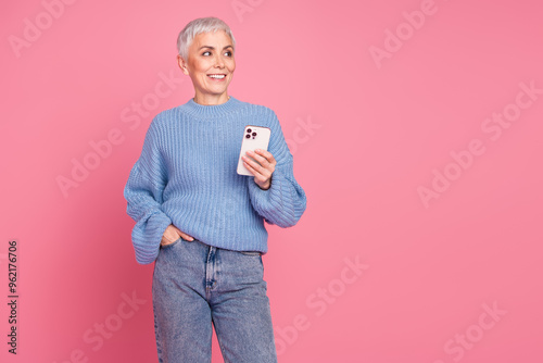 Photo portrait of pretty retired female look empty space hold gadget wear trendy blue knitwear outfit isolated on pink color background