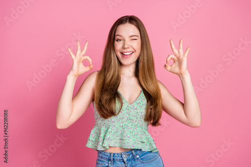 Portrait of nice young woman okey symbol eye wink wear singlet isolated on pink color background