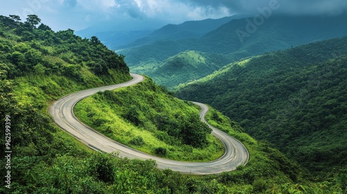 A mountain road switchback, with sharp, curving lines of the road cutting through a lush landscape