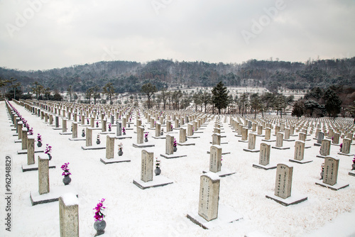 Dongjak-gu, Seoul, South Korea - January 28, 2021: Snow covered tombstones at Seoul National Cemetery