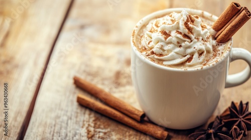 A white coffee cup with whipped cream and cinnamon sticks on top