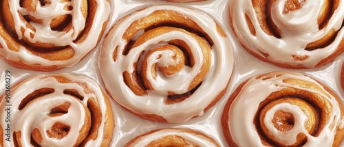 A close up of a plate of cinnamon rolls with a white glaze