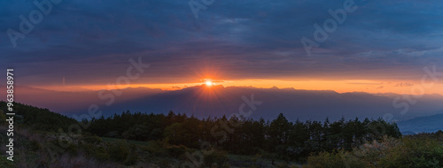 日本 長野県岡谷市と塩尻市の境にある高ボッチ山の高ボッチ高原から見える夕陽の光芒と雲から顔を出した夕日