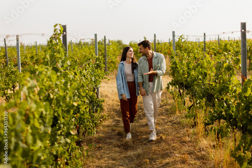 A charming couple strolls hand in hand through sunlit vineyards on a warm afternoon, enjoying the beauty of nature and each other's company