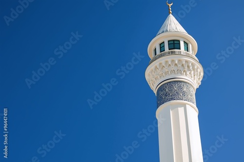 A detailed view of an ornate minaret with intricate patterns, set against a bright, clear blue sky, representing Islamic architecture.