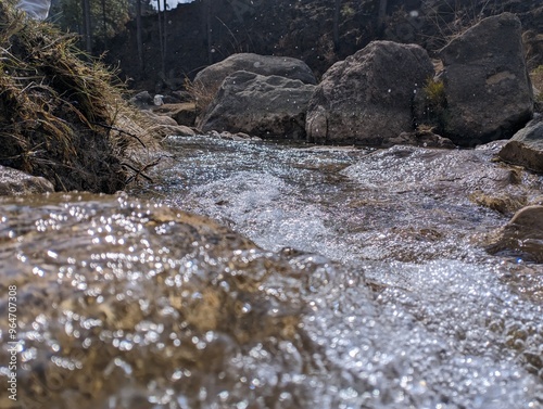 stream of river flowing between rocks in a valley