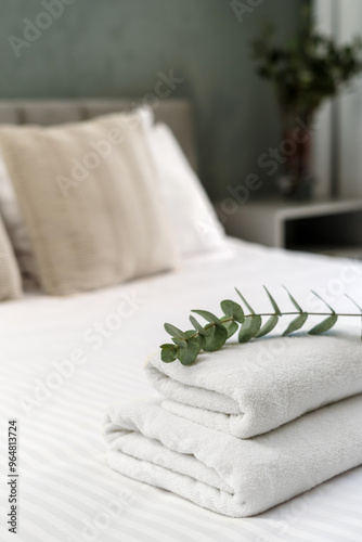 Neat stack of folded towels placed on a bed