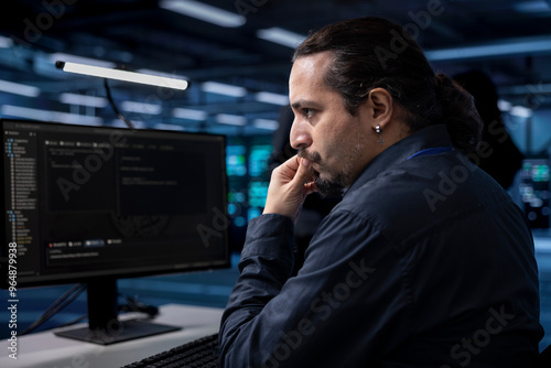 Computer scientist doing maintenance in server room to extend equipment life span and avoid downtime. IT professional monitoring rackmounts for overheating problems and power fluctuations