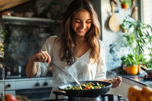 Happy young woman in a cozy kitchen, sautÃ©ing vegetables with a relaxed smile, savoring the experience of cooking a healthy and delicious meal at home