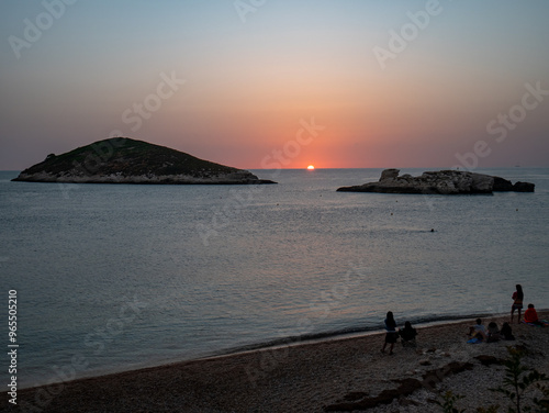 people wait for the dawn on the Adriatic Sea and Campi island. Baia and Cala Campi, Vieste, Gargano National Park. Italy